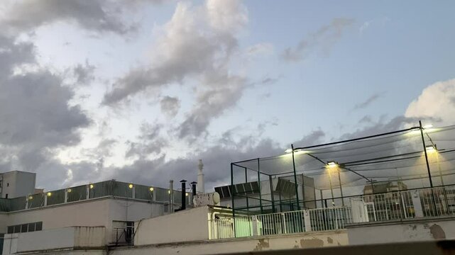 CIelo encapotado con nubes de tormenta en la ciudad. Skyline de edificios y pistas de padel