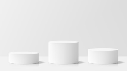 Three white cylinder podiums of different heights for product display. Minimalist presentation background with geometric shapes.