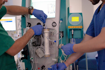 Medical professionals operating dialysis machine in hospital