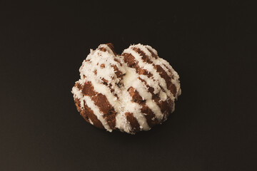 Profiteroles with coconut cream on a black background.