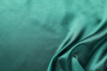 Crumpled green silk fabric as background, top view