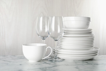 Different clean dishware on white marble table indoors