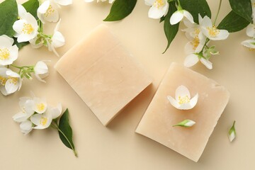 Soap bars and jasmine flowers on beige background, flat lay