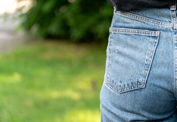 A close-up view captures the texture and stitching of denim jeans while highlighting the relaxed...
