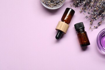 Natural essential oil and lavender flowers on lilac background, flat lay. Space for text