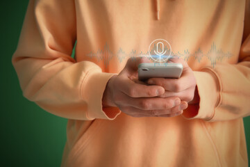 Man using mobile phone on green background, closeup