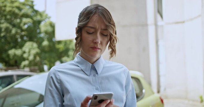 A concerned young woman makes an important phone call on her mobile phone, displaying frustration and stress. Her worried expression suggests she is dealing with a difficult situation or problem.