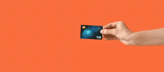  Hand with credit card on orange background © Pixel-Shot