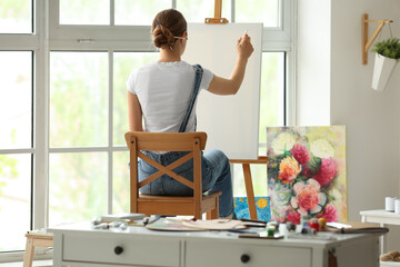 Female artist painting picture in  workshop