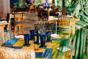 Cozy dining area with blue glassware and natural decor in a tropical restaurant setting