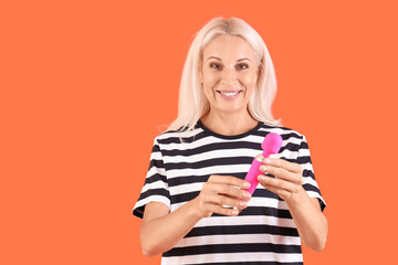 Mature woman with vibrator on red background