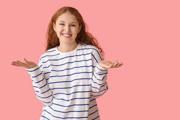 Portrait of nervous young woman shrugging on pink background