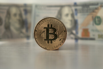 Bitcoin coin lies on the background of dollars