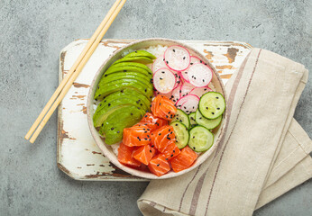 Poke bowl, a traditional hawaiian dish with diced raw salmon, avocado, vegetables served with rice and vegetables, a healthy meal