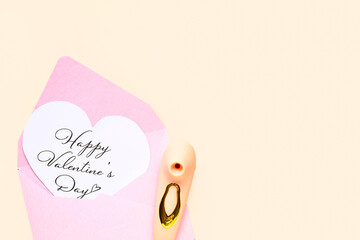 Card with text HAPPY VALENTINES DAY, envelope and vibrator on beige background
