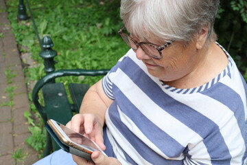 senior women using smartphone in the park