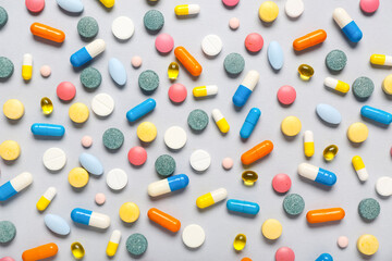 Different colorful pills on grey background
