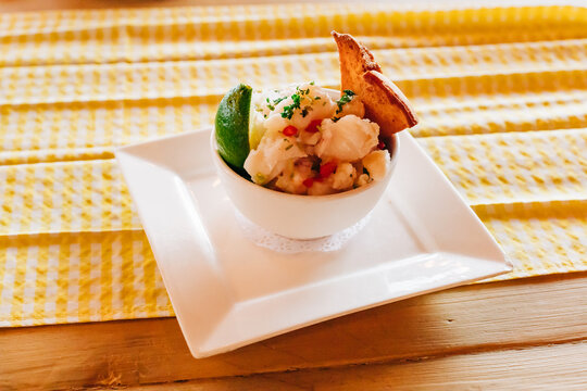 Refreshing seafood ceviche served with lime and crispy tortilla chips on a vibrant yellow tablecloth