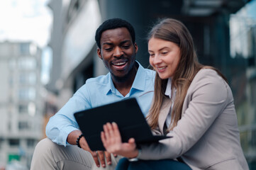 Business colleagues collaborating on tablet in urban setting