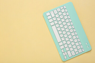 Stylish cyan keyboard on beige background