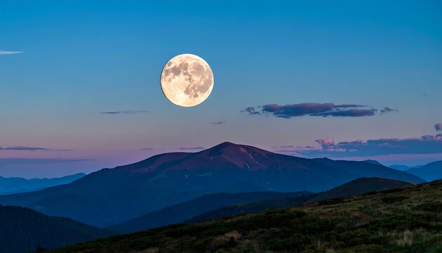 Full moon over mountain range at twilight