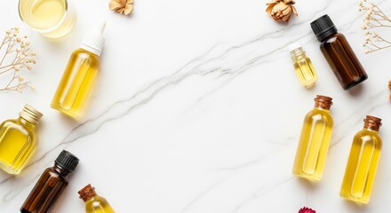 Assorted aromatherapy bottles on marble background with dried flowers