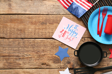 Composition with greeting card for Independence Day celebration, dinnerware and barbecue utensils...