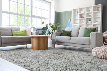 Interior of stylish modern living room with surfboard and sofas
