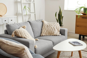 Interior of living room with cozy grey sofa and coffee table