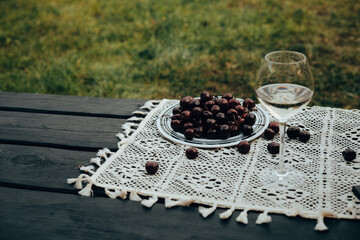 A glass of white wine and a plate of cherries on a table outside on a sunny day. A refreshing glass...