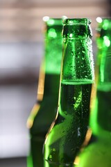 Bottles of beer on blurred grey background, macro view