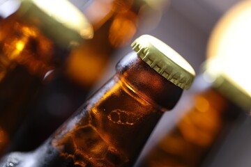 Bottle of tasty beer on blurred grey background, macro view