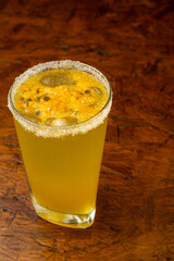 Refreshing passion fruit (maracuyá) cocktail or Lulada with a sugar rim and fresh seeds, an exotic...