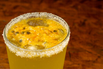 Refreshing passion fruit (maracuyá) cocktail or Lulada with a sugar rim and fresh seeds, an exotic...