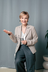 Portrait of happy woman. Confident, successful mature woman on light gray background. Looking at...