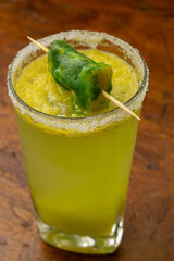 Creative frozen mango or lulo Margarita cocktail with a salt rim and a green ice pop (popsicle)...