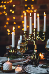 Rustic Scandinavian style zero waste eco-friendly dinner table decor for Christmas or new year family celebration. Wooden table, natural elements like pine cones, fir tree branches, candles