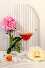 Modern still life with pink martini, summer alcoholic cocktail with apricot for party and peonies on elegant modern background, minimalist concept for bar, cafe, advertising banner, selective focus