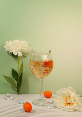 Minimal still life with flowers and alcohol. Royal lemonade cocktail with tequila, gin, rum, ice and fresh apricot berries, bar and party concept with peonies, restaurant and cafe advertising card,