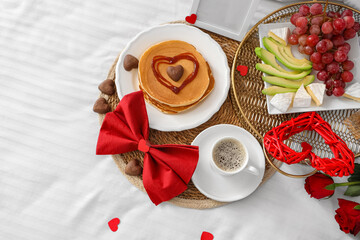 Tasty breakfast for Valentine's Day on bed, top view
