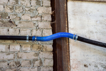 Construction work displays pipes joined using blue tubing along a rugged wall, showcasing...