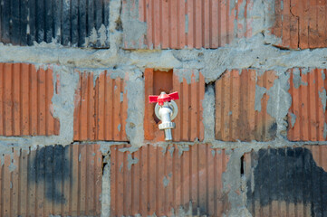 Fire safety gear is securely attached to a brick wall in a construction site, ensuring safety...