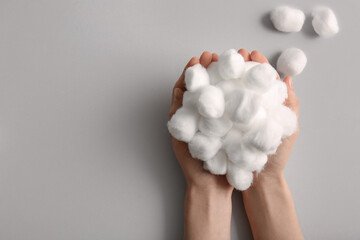 Female hands with cotton balls on grey background