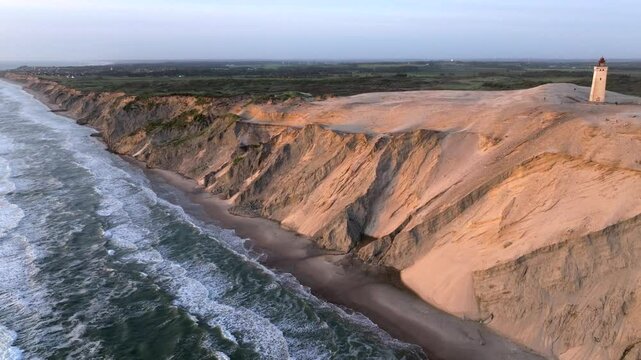 Aerial view of the giant sand dunes with the famous lighthouse on the top of a hill. Rubjerg Knude Lighthouse, , North SeaRubjerg , Sunset at the lighthouse Rubjerg Knude Fyr near Lokken in Denmark. 