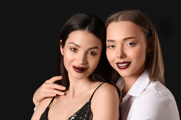 Two different young women hugging on black background. Yin Yang concept
