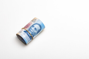 Roll of Mexican pesos against a stark white background.
