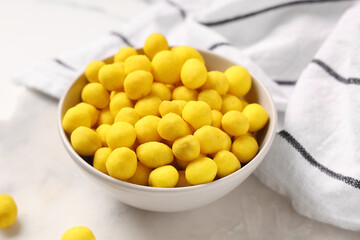Bowl with cheese coated peanuts on light background