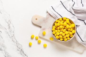 Bowl with cheese coated peanuts on marble background