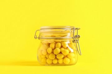 Jar with cheese coated peanuts on yellow background