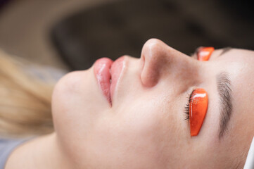 Caucasian woman undergoing eyelash lamination procedure. 